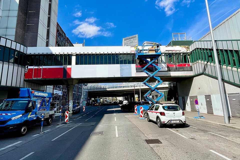 Wiener Linien Steg Erdberg Branding. Arbeiter auf Hebebühne. Plakativ.