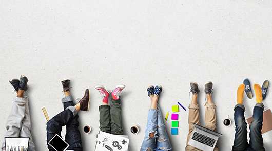 Team Schuhe Vielfalt: Füße mit Schuhen, Laptop, Kaffee, Notizen. Kreatives Team, Büroalltag.