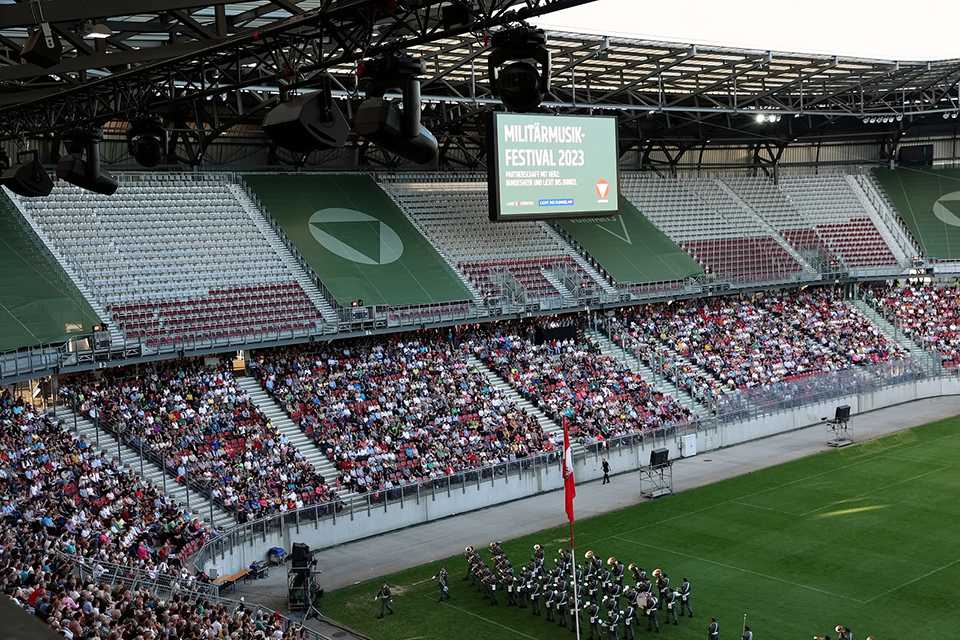 Militärmusik Festival 2023 in Klagenfurt: Stadion mit Publikum und Militärorchester.