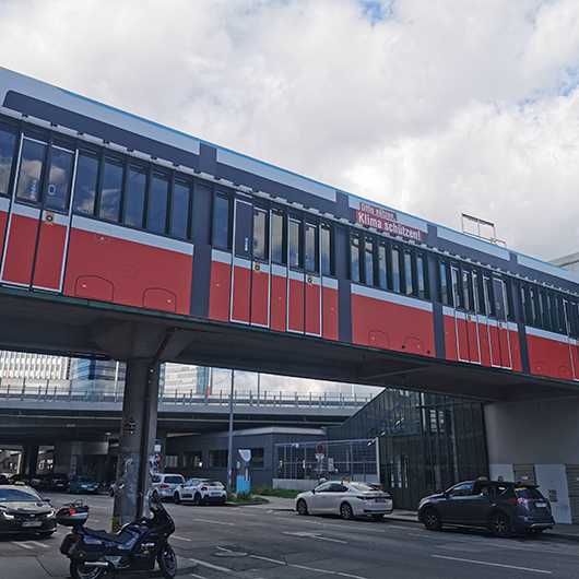 Branding Steg Erdberg, Wien. Wiener Linien Werbung für Klimaschutz auf Fußgängerbrücke.