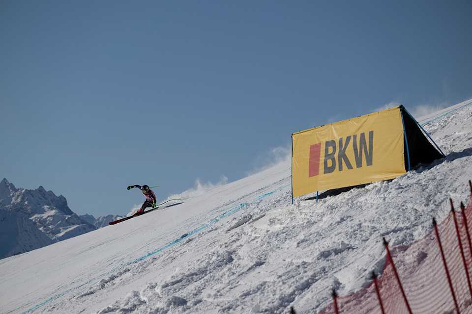 Ski Weltcup St. Moritz: Skirennläufer vor BKW Banner. Nachhaltiger Werbeauftritt im Schnee.