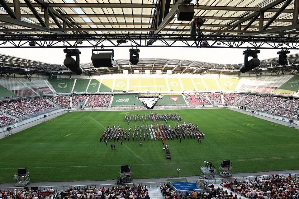 Militärmusik Festival 2023 in Klagenfurt. Stadion voll mit Zuschauern und Militärorchester.